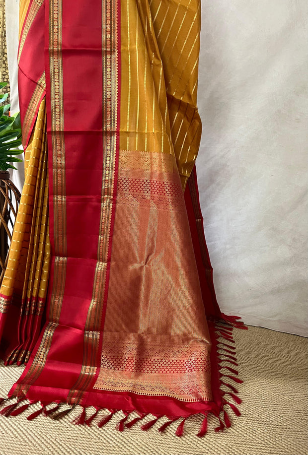 Mustard yellow and red Kanchivaram saree with stitched blouse